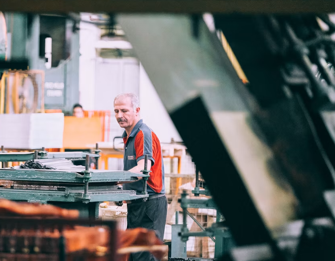 Factory worker operating machinery on a manufacturing production line