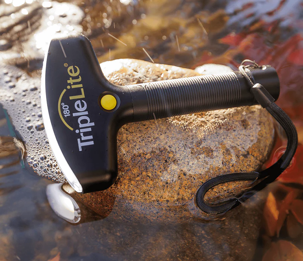 TripleLite 180° rechargeable lantern resting on a wet rock outdoors