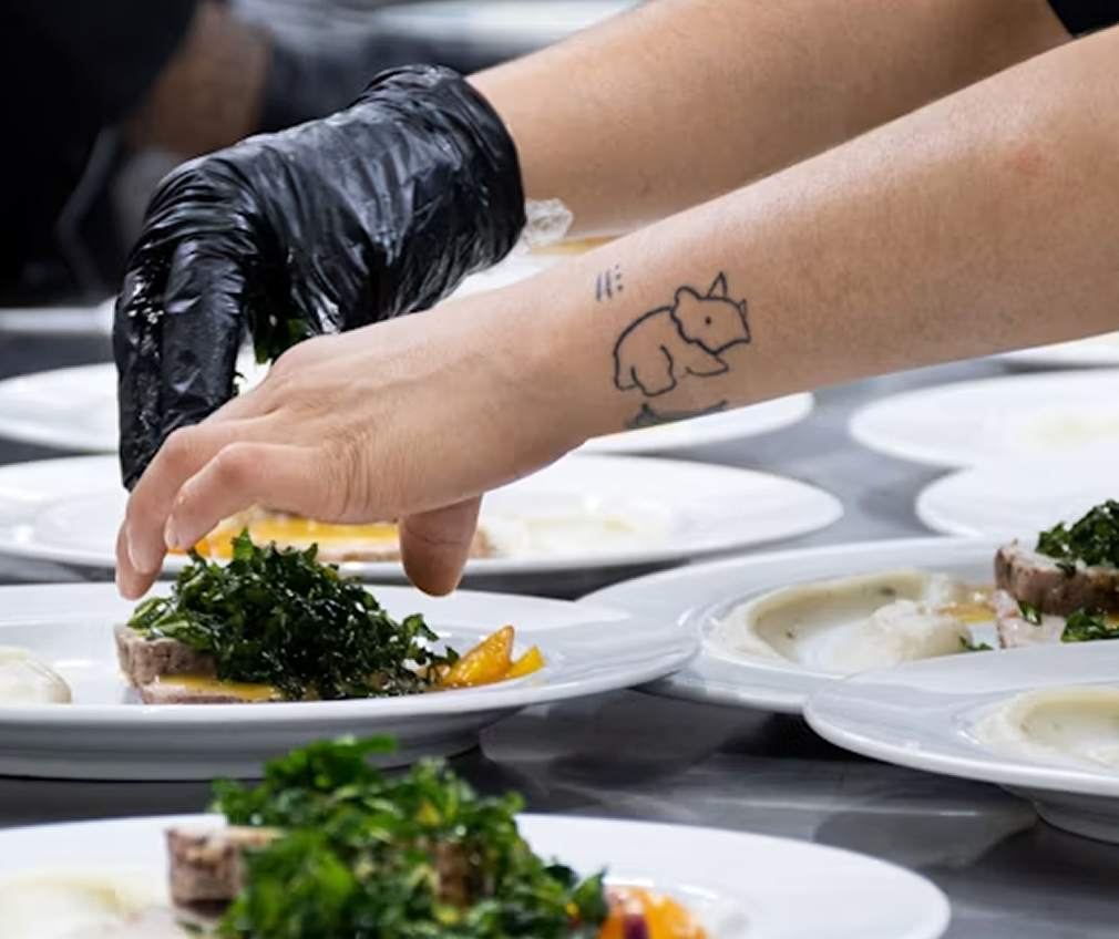 Chef plating dishes in a catering kitchen