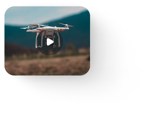 Drone photo of a rural landscape with a video play button overlay